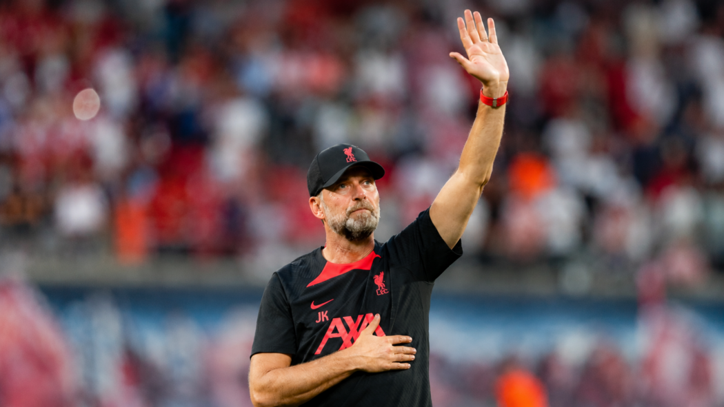 Jürgen Klopp raises a hand to acknowledge supporters inside a football stadium