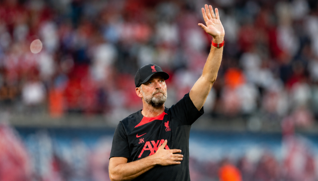 Jürgen Klopp raises a hand to acknowledge supporters inside a football stadium