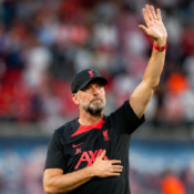 Jürgen Klopp raises a hand to acknowledge supporters inside a football stadium