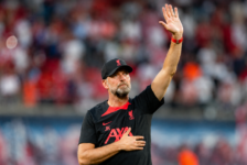 Jürgen Klopp raises a hand to acknowledge supporters inside a football stadium