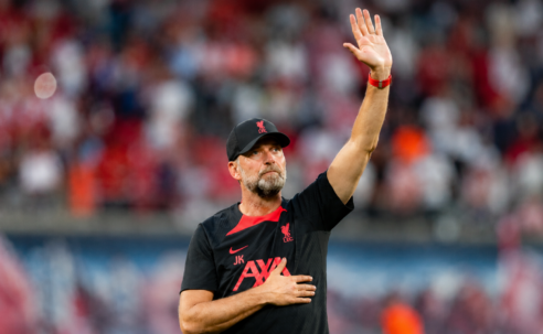 Jürgen Klopp raises a hand to acknowledge supporters inside a football stadium