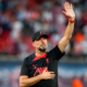 Jürgen Klopp raises a hand to acknowledge supporters inside a football stadium